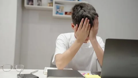 Stressed young boy using laptop at home feeling frustration Stock Footage 333330336