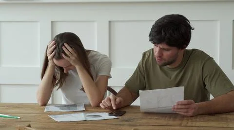 Stressed young couple calculating monthly home expenses, credit card bills Foto stock