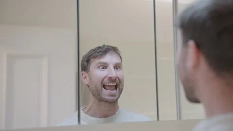 Stressed young man baring his teeth and making angry, funny faces at his Stock Footage 335152254