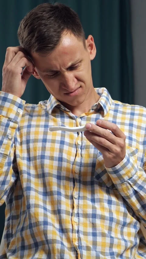 Stressed young man discovering an unplanned pregnancy result with a positive Stock Footage 343909334