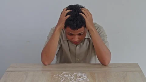 Stressed young man feeling overwhelmed and hopeless while staring at messy knot Stock Footage 334251470