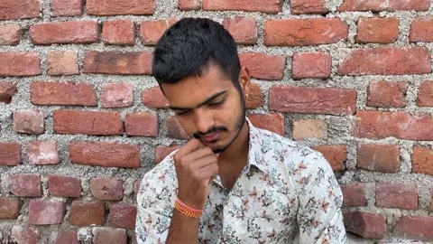 Stressed Young Man Sitting Alone with Brick Wall Background Stock Footage 321515611