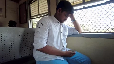Stressed young man using a smartphone while traveling on a train in India Vídeo Stock 341324681