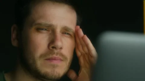 Stressed young professional experiencing intense eye strain and migraine while Stock Footage 312983226