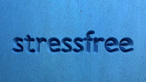 Stressfree word carved in a blue wall Stock Footage
