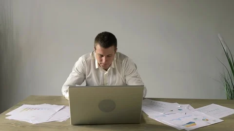 Stressful businessman throws off paper documents and laptop from the table Stock Footage 110941456