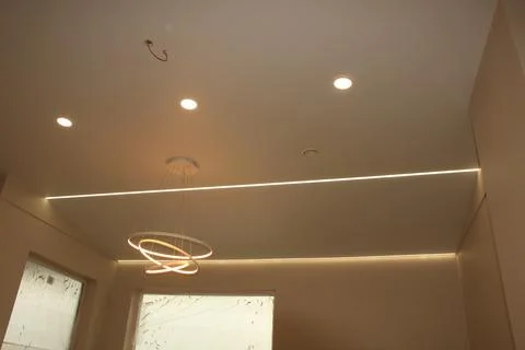Stretch ceiling with led strip, pendant light and recessed lighting Stock Photos