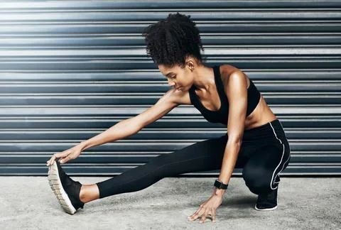 Stretch past all your limits. a sporty young woman stretching her legs against a Stock Photos