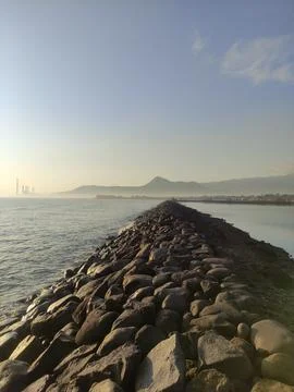 Stretch of wave retaining wall made of piles of large stones Stock Photos