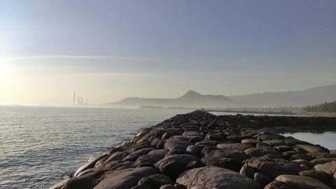 Stretch of wave retaining wall made of piles of large stones installed  Stock Photos