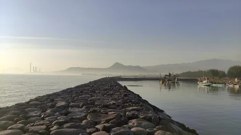 Stretch of wave retaining wall made of piles of large stones installed  Stock Photos