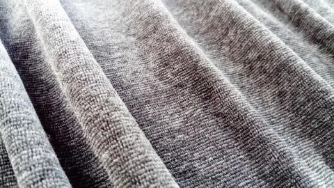 Stretched elastic fabric. Gray material laid in waves. Cloth for sewing cover Foto stock