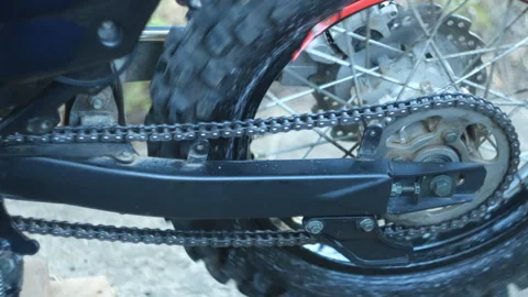 A stretched motorcycle chain is spinning Stock Footage 252281381