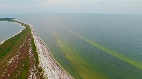 Stretched ocean lagoon flyover on a calm, cloudy day Stock Footage 54943094