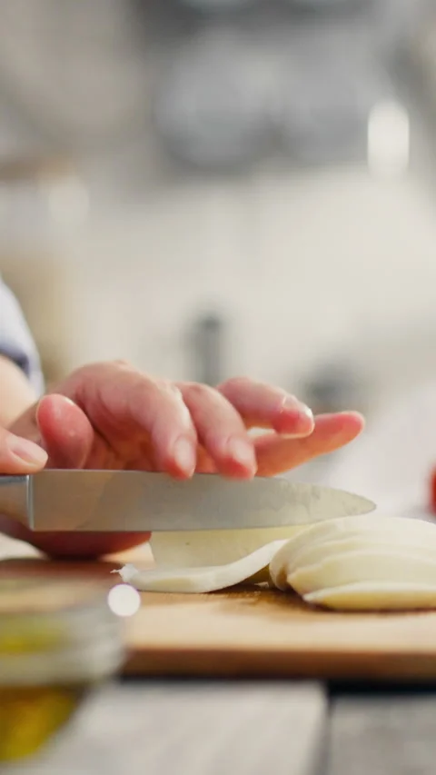 Stretched Screen. Basil leaf, expectant mother cuts mozzarella on kitchen su Stock Footage 331728987