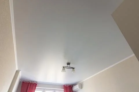 Stretched white matte ceiling in the room close-up Stock Photos