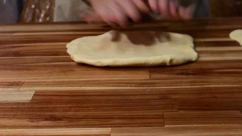 Stretching elastic bread dough on a wooden table for home baking Stock Footage 334463439