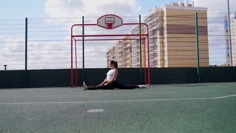 Stretching gymnast woman doing split, twine in workout sports ground. Stock Footage 122987703