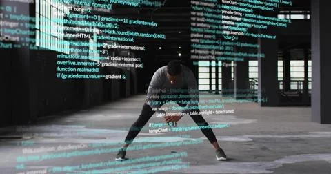 Stretching man in athletic gear performing lateral split in warehouse, with Stock Photos