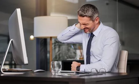 Stretching more often will probably prevent this. a businessman suffering with Stock Photos