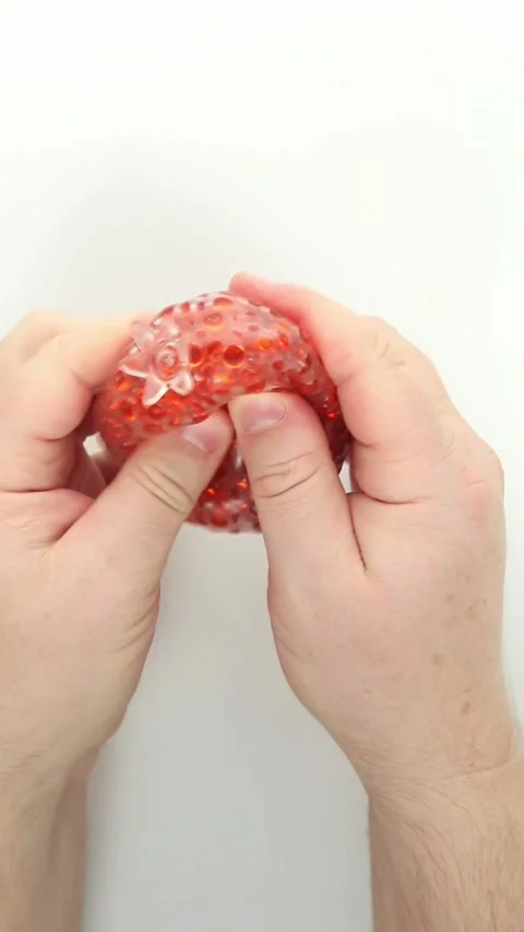 Stretching transparent bead-filled slime stress toy on white Stock Footage 336264654