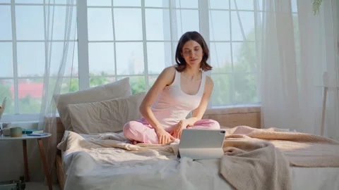Stretching woman watching laptop tutorial at morning bedroom. Relaxed lady Stock Footage 332709432