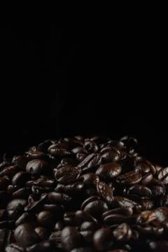 Strewing coffee beans falling down concept on dark background Stock Photos