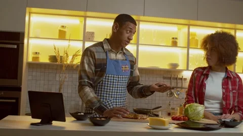 Strict African American man refusing help from woman during cooking dinner Stock Footage 232914114