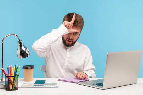 Strict annoyed boss showing loser gesture with fingers talking video call wit Stock Photos