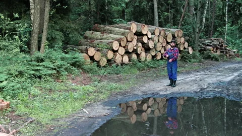 A strict brutal logger in overalls with a beard and an axe against the Stockbeeldmateriaal 135581800