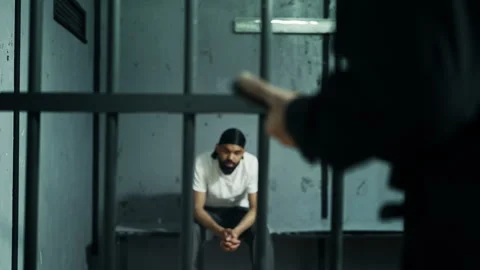 Strict prison guard threatening inmate with baton, symbol of power and dominance Stock Footage 319009879
