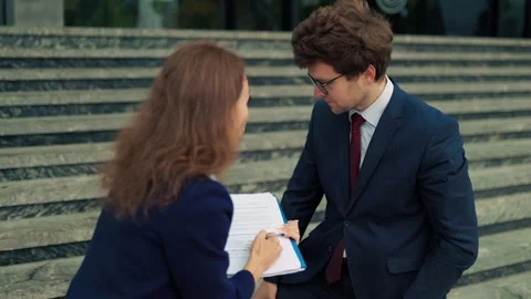 Strict supervisor pointing pen at document mistake on folder. Anxious worker Stock Footage 348875179