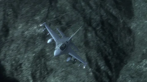 A strike aircraft flies over hilly terrain under cover of night. 動画素材 335650486