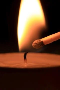 To strike candle by match Stock Photos