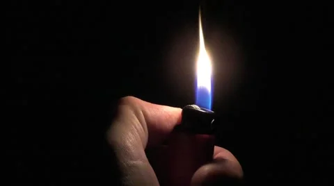 Strike a lighter to light a fire in the dark flame gas lighter Video stock 58538849
