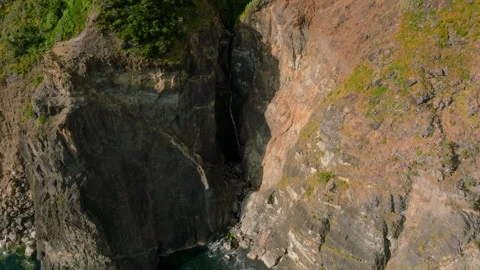 Striking Aerial Perspective of a Thin Waterfall Carving Through Ancient 库存影片 336262718