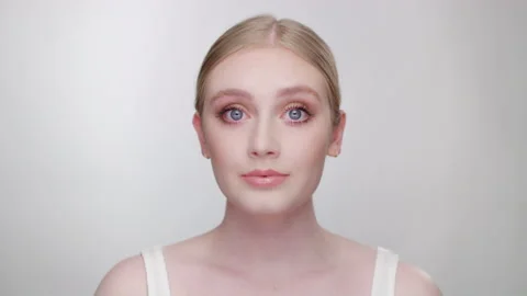 Striking blonde model evaluates her appearance in mirror, looking into camera Stock-Footage 193715014