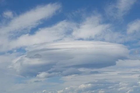 A striking, circular cloud formation is visible against a bright blue sky f.. Stock Photos