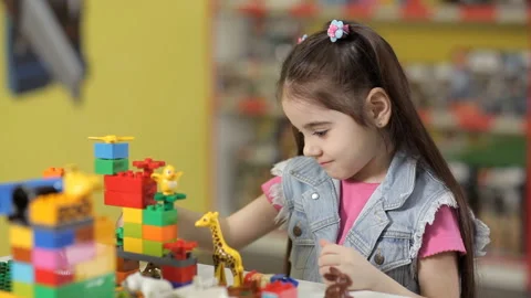 Striking girl plays with plastic objects, blocks of children's designer Vídeo Stock 87960924