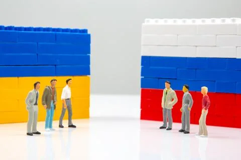 A striking image of tiny figures divided by blocks block walls in Ukrainian.. Stock Photos