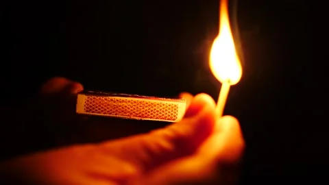 Striking a match creating a flame in slow motion isolated on black holding match Stock-Footage 206283054