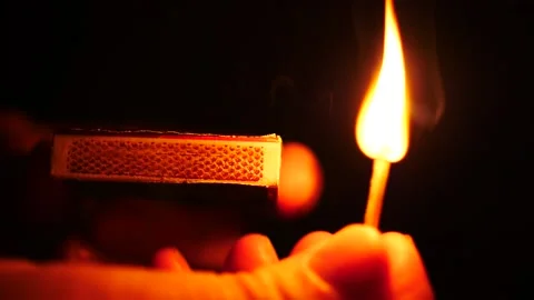 Striking a match in slow motion close up on hand isolated on black Stock Footage 206283055