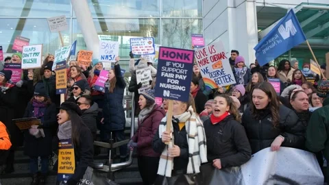 Striking nurses with placards, in protest of government cuts and unfair pay. Stock Footage 231612361