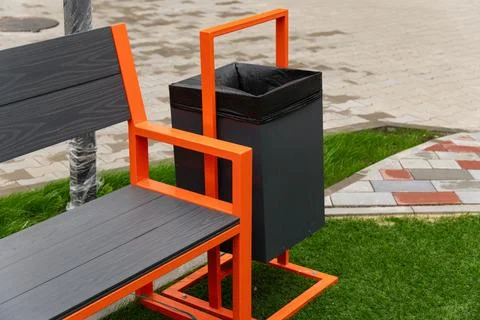 The striking orange bench designed with an attached black trash bin offers .. Stock Photos