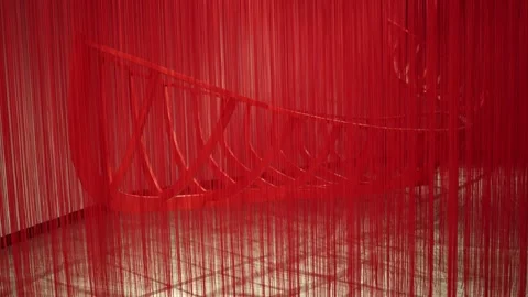 A striking red art installation featuring cascading threads partially obscuring  Stock Footage 304358255