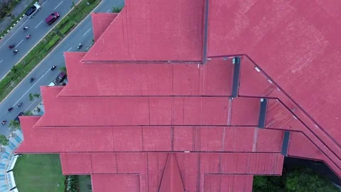 Striking red roof structures overlook a busy Indonesian urban road, depicti.. Video stock 325263271