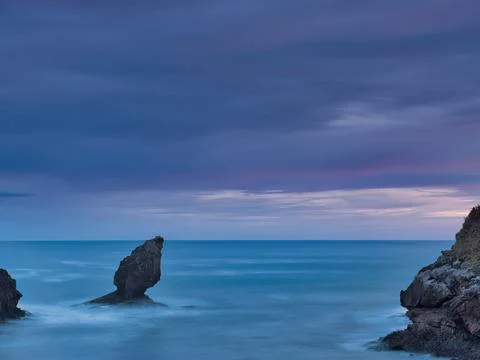 Striking Sea Stack Under Twilight Sky - Vertical long exposure capturing a .. Stock Photos