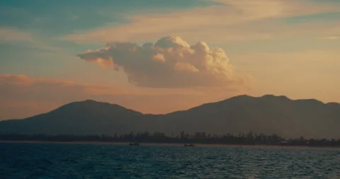 Striking sunset silhouette of a mountain range across the calm ocean Vídeo Stock 342469764