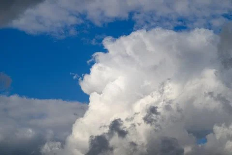 A striking view of fluffy clouds against a bright blue sky, evoking peace and 写真素材