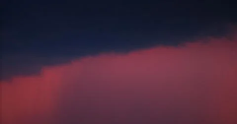 A striking visual of dark clouds contrasting with a fiery gradient sky at sun Stock Photos